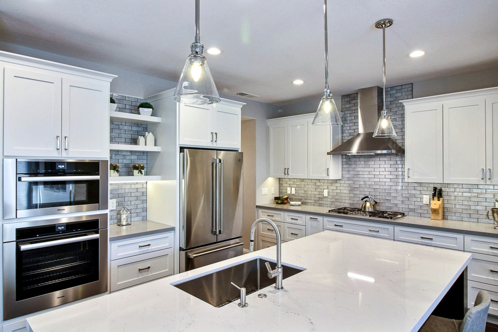 Foto di una cucina design con lavello a vasca singola, ante in stile shaker, ante bianche, paraspruzzi grigio, elettrodomestici in acciaio inossidabile, parquet scuro, pavimento marrone e top grigio