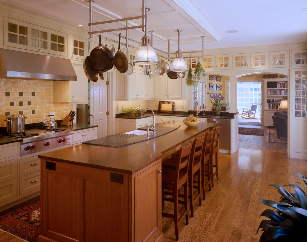 Exempel på ett mellanstort klassiskt kök, med en rustik diskho, luckor med infälld panel, vita skåp, bänkskiva i koppar, vitt stänkskydd, stänkskydd i sten, rostfria vitvaror, ljust trägolv och en köksö