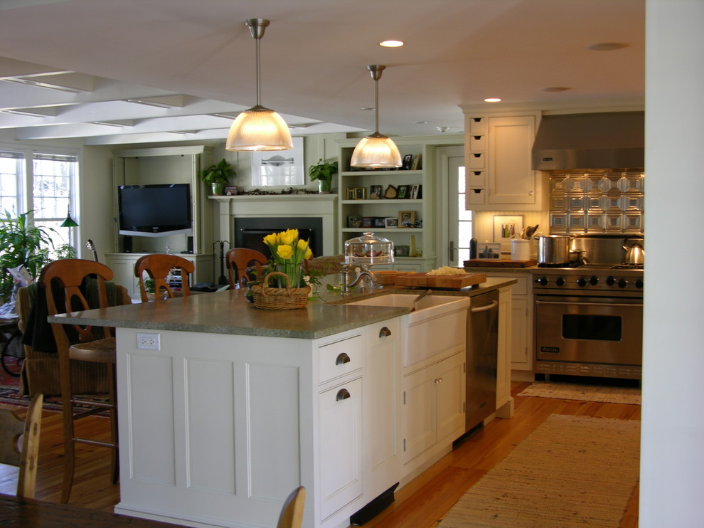 Example of a small classic l-shaped medium tone wood floor open concept kitchen design in Boston with a farmhouse sink, beaded inset cabinets, white cabinets, granite countertops, metallic backsplash, metal backsplash, stainless steel appliances and an island