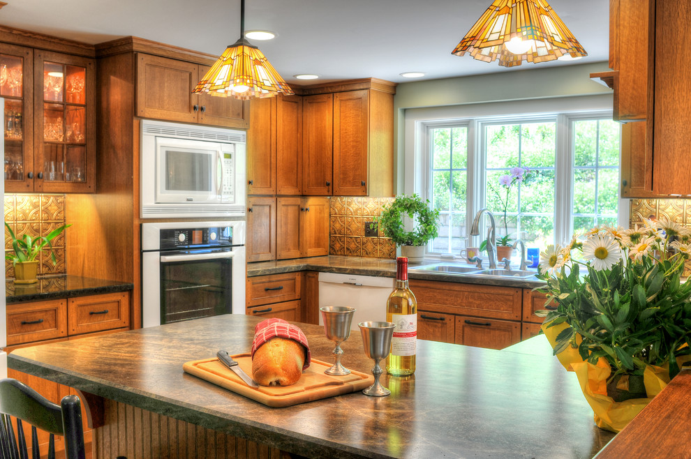 Example of a mid-sized classic u-shaped medium tone wood floor and brown floor eat-in kitchen design in Boston with a double-bowl sink, glass-front cabinets, brown cabinets, laminate countertops, brown backsplash, white appliances, metal backsplash and no island