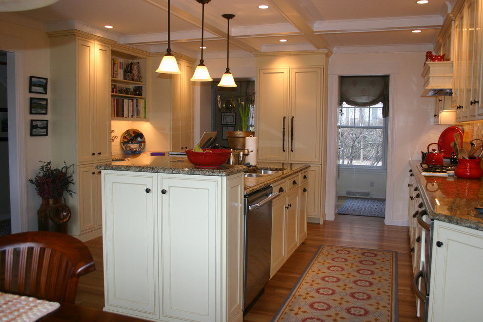 Inspiration for a timeless galley eat-in kitchen remodel in Boston with a double-bowl sink, recessed-panel cabinets, yellow cabinets, granite countertops, yellow backsplash, ceramic backsplash and paneled appliances