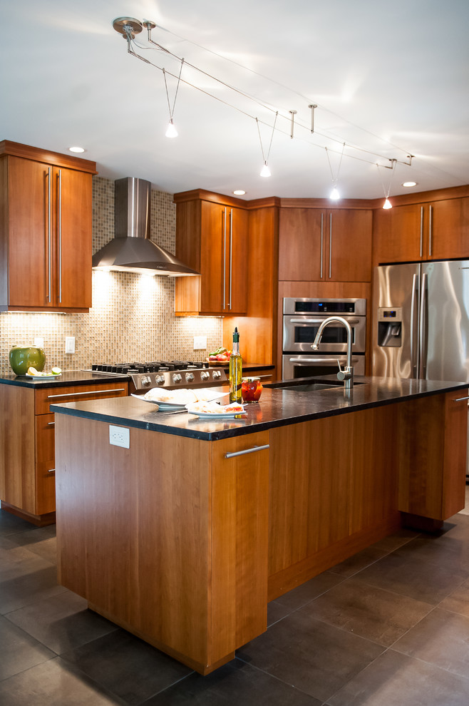 Idée de décoration pour une cuisine américaine parallèle minimaliste en bois brun de taille moyenne avec un évier encastré, un placard à porte plane, un plan de travail en granite, une crédence multicolore, une crédence en carreau de verre, un électroménager en acier inoxydable, un sol en carrelage de porcelaine et îlot.