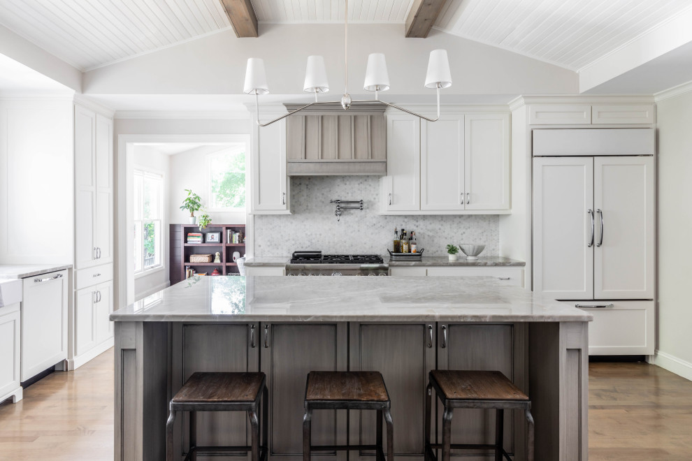 Example of a mid-sized transitional l-shaped medium tone wood floor and brown floor kitchen design in Charlotte with recessed-panel cabinets, white cabinets, multicolored backsplash, stainless steel appliances, an island and gray countertops