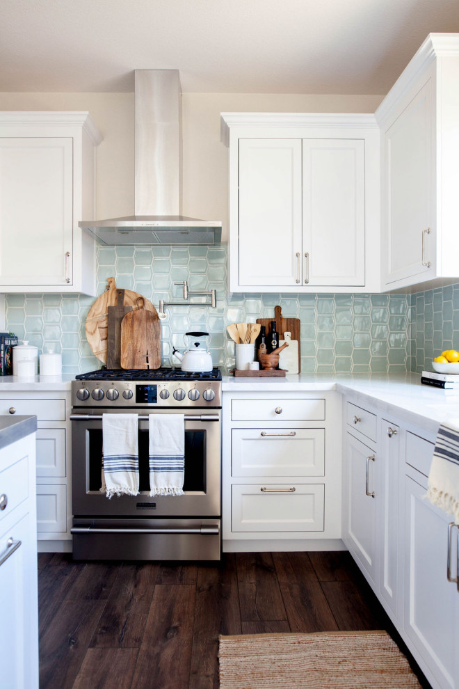 Klassische Küche in L-Form mit Schrankfronten mit vertiefter Füllung, weißen Schränken, Küchenrückwand in Grün, Küchengeräten aus Edelstahl, dunklem Holzboden, Kücheninsel, braunem Boden und weißer Arbeitsplatte in Sacramento
