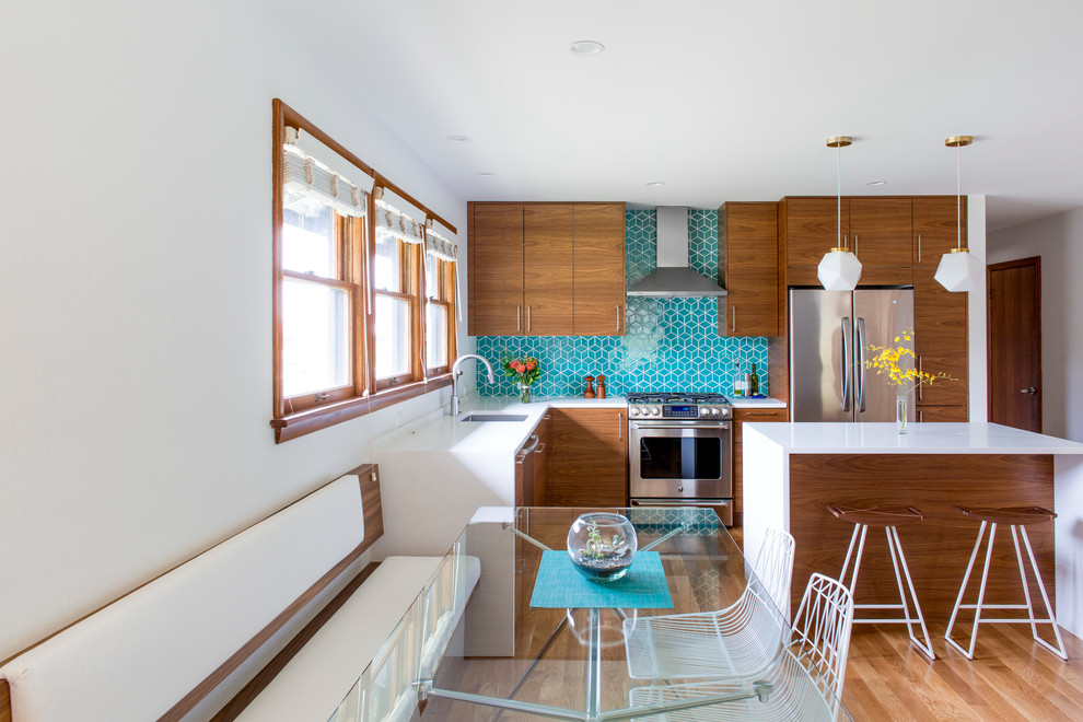 Mid-sized mid-century modern l-shaped medium tone wood floor eat-in kitchen photo in Portland with an undermount sink, flat-panel cabinets, white cabinets, quartz countertops, blue backsplash, ceramic backsplash, stainless steel appliances and an island