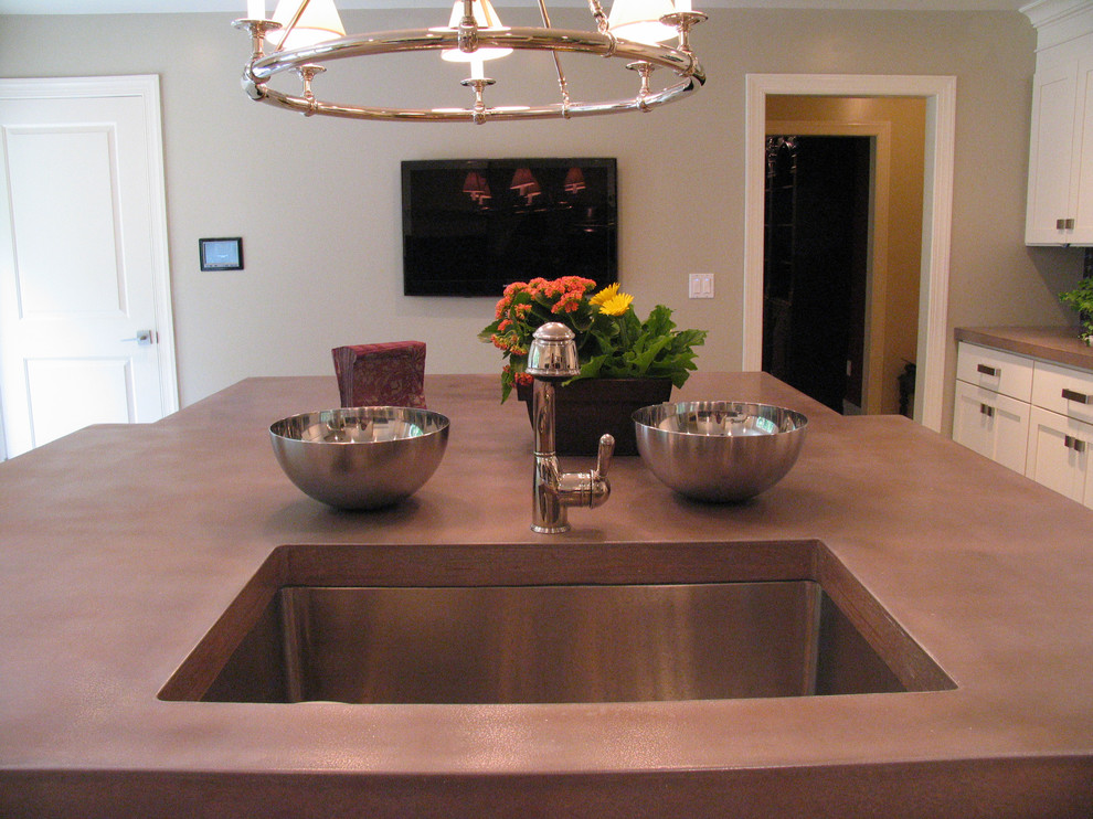 Пример оригинального дизайна: большая п-образная кухня в современном стиле с обеденным столом, врезной мойкой и столешницей из бетона