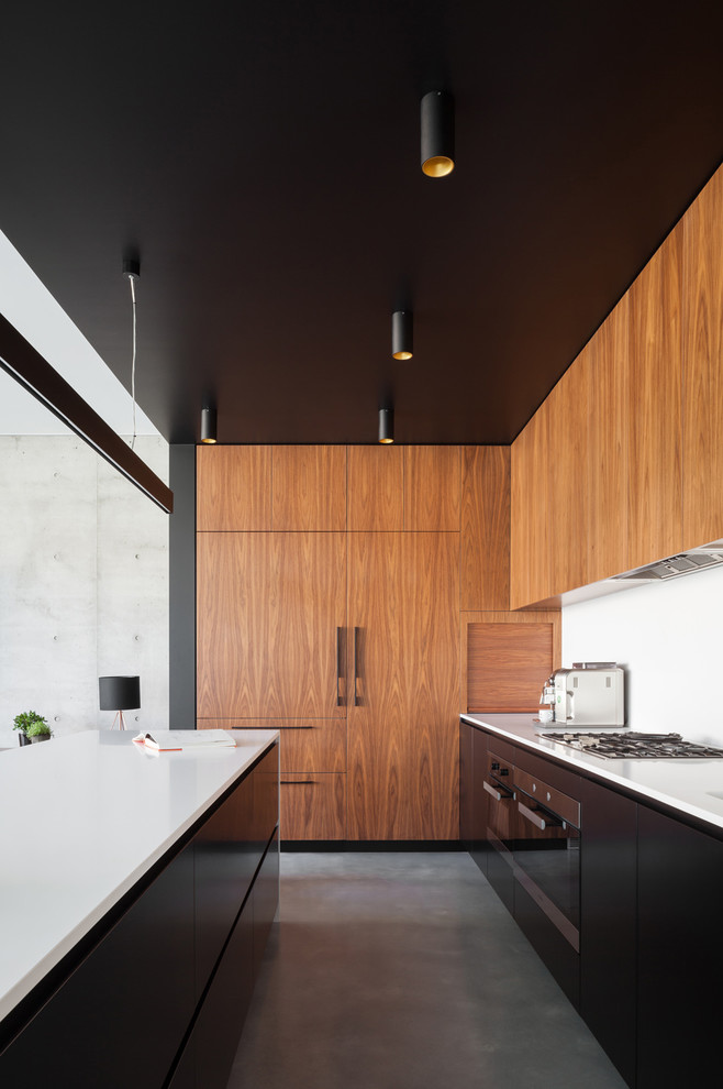 Mittelgroße Moderne Wohnküche in L-Form mit Quarzwerkstein-Arbeitsplatte, Küchenrückwand in Weiß, Betonboden, Kücheninsel, integriertem Waschbecken, schwarzen Schränken, Rückwand aus Stein und schwarzen Elektrogeräten in Sydney
