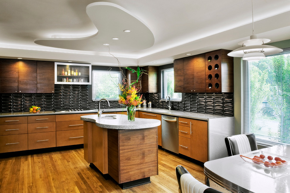 Aménagement d'une cuisine américaine moderne en L et bois brun avec un évier encastré, un placard à porte plane, une crédence grise, un électroménager en acier inoxydable et une crédence en céramique.
