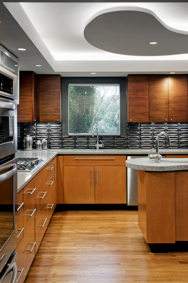Immagine di una cucina a L moderna con lavello sottopiano, ante lisce, ante in legno scuro, paraspruzzi grigio e elettrodomestici in acciaio inossidabile