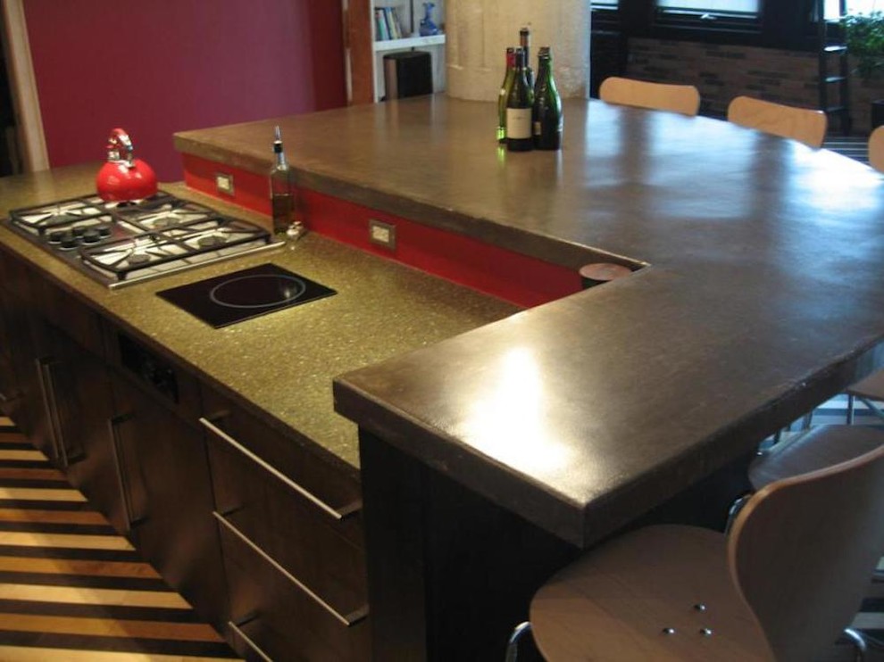 Idee per una cucina moderna di medie dimensioni con ante lisce, ante in legno bruno, top in granito, paraspruzzi rosso, elettrodomestici in acciaio inossidabile e moquette