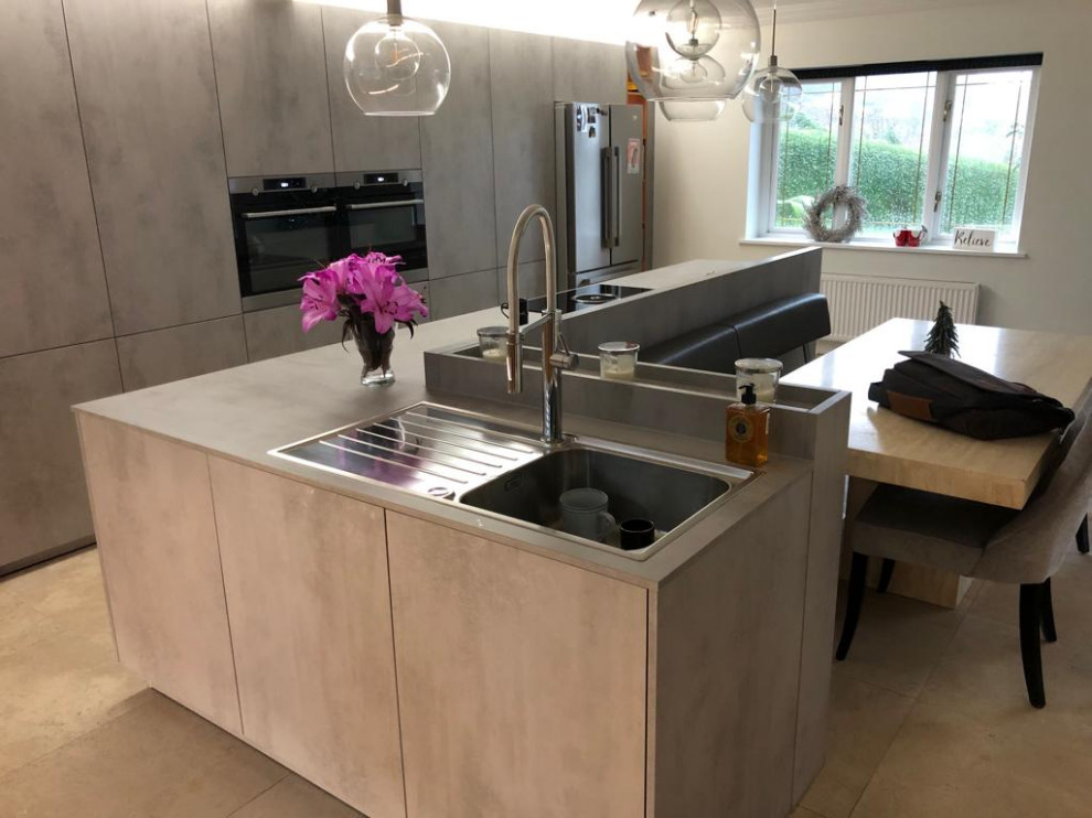 This is an example of a medium sized modern single-wall kitchen/diner in Cardiff with an integrated sink, flat-panel cabinets, grey cabinets, laminate countertops, stainless steel appliances, ceramic flooring, an island, beige floors and grey worktops.