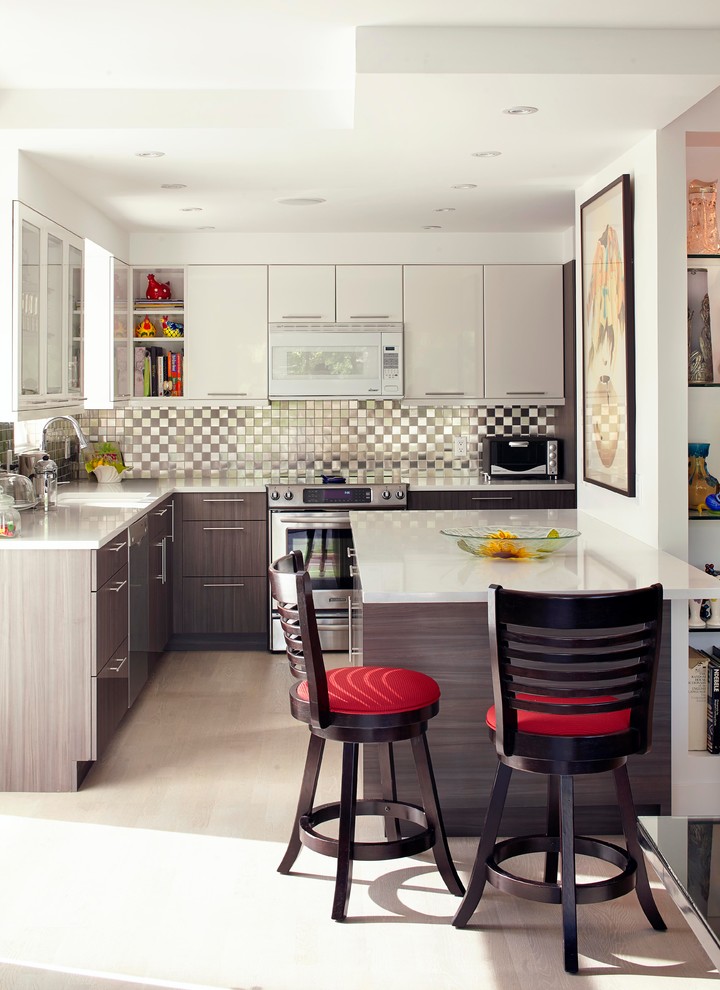 Offene Moderne Küche in L-Form mit flächenbündigen Schrankfronten, grauen Schränken, Küchenrückwand in Metallic, Rückwand aus Metallfliesen, Küchengeräten aus Edelstahl und hellem Holzboden in Montreal