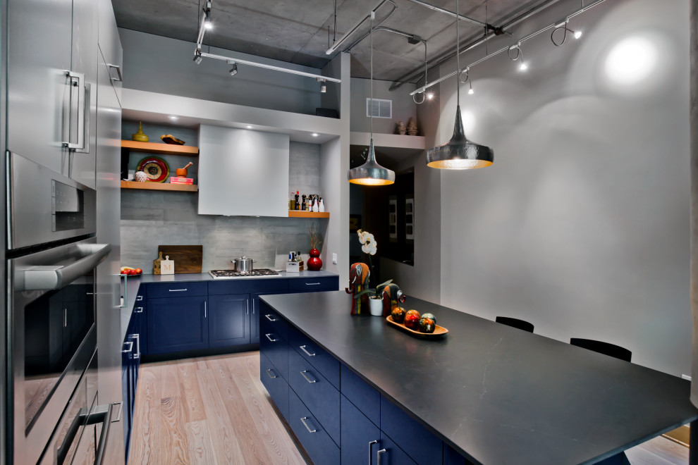 Inspiration for a mid-sized transitional l-shaped light wood floor and brown floor eat-in kitchen remodel in Minneapolis with an undermount sink, recessed-panel cabinets, blue cabinets, quartz countertops, beige backsplash, ceramic backsplash, paneled appliances, an island and blue countertops