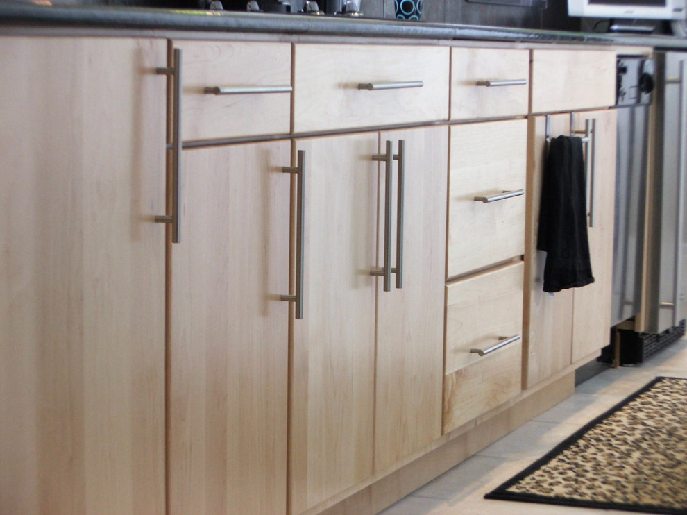 Esempio di una cucina minimalista con lavello sottopiano, ante lisce, ante in legno chiaro, top in granito, paraspruzzi a effetto metallico, paraspruzzi con piastrelle in ceramica e elettrodomestici in acciaio inossidabile