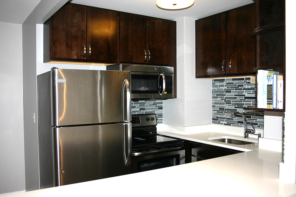 Foto på ett funkis kök, med en undermonterad diskho, luckor med lamellpanel, skåp i mörkt trä, bänkskiva i kvarts, grått stänkskydd och rostfria vitvaror
