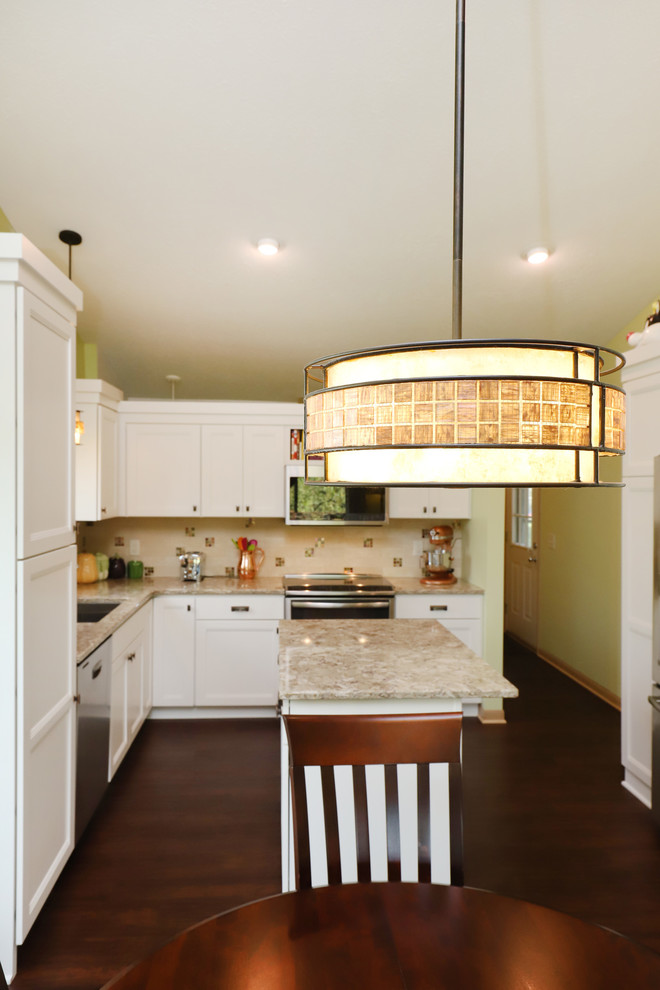 Inredning av ett klassiskt mellanstort kök, med luckor med infälld panel, vita skåp, granitbänkskiva, flerfärgad stänkskydd, stänkskydd i keramik, rostfria vitvaror, laminatgolv, en köksö, brunt golv och en dubbel diskho
