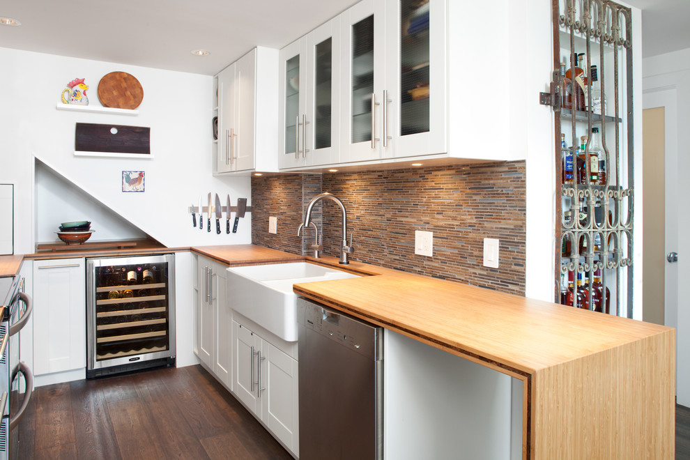 Foto på ett litet vintage kök, med en rustik diskho, luckor med upphöjd panel, vita skåp, träbänkskiva, brunt stänkskydd, stänkskydd i stickkakel, rostfria vitvaror och mellanmörkt trägolv