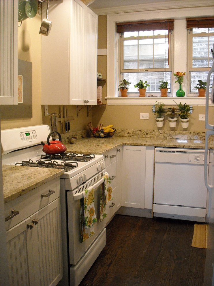 Photo of a small traditional u-shaped enclosed kitchen in Chicago with beaded cabinets, white cabinets, granite worktops, beige splashback, white appliances, dark hardwood flooring and no island.