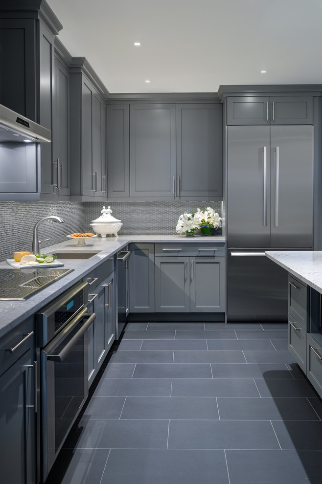 Inredning av ett modernt litet kök, med en enkel diskho, luckor med infälld panel, grå skåp, bänkskiva i kvarts, flerfärgad stänkskydd, stänkskydd i glaskakel, rostfria vitvaror, klinkergolv i porslin och en halv köksö