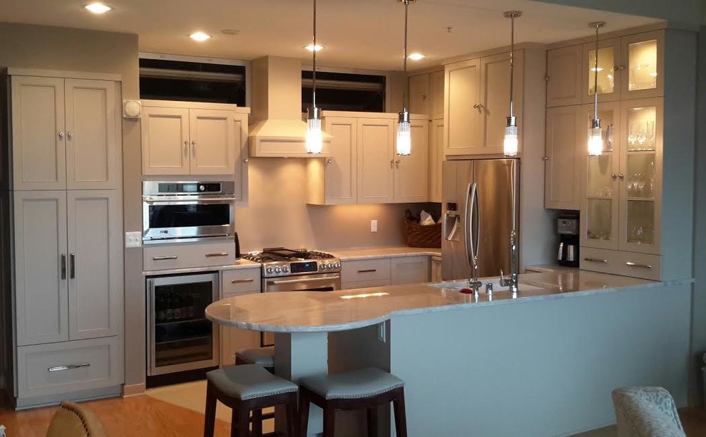 Mid-sized trendy galley porcelain tile eat-in kitchen photo in Milwaukee with an undermount sink, gray cabinets, quartzite countertops, stainless steel appliances and an island