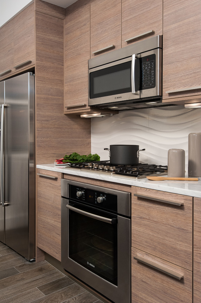 Immagine di una piccola cucina minimal con ante lisce, ante in legno scuro, paraspruzzi beige e elettrodomestici in acciaio inossidabile