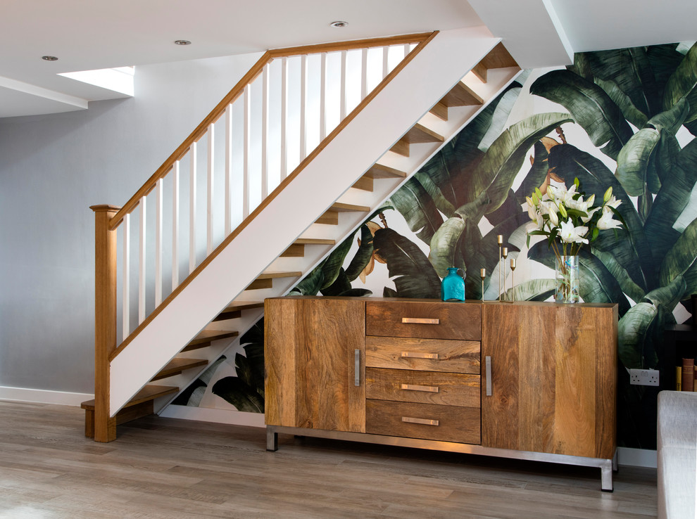 Diseño de escalera nórdica de tamaño medio con contrahuellas de madera, barandilla de madera y papel pintado