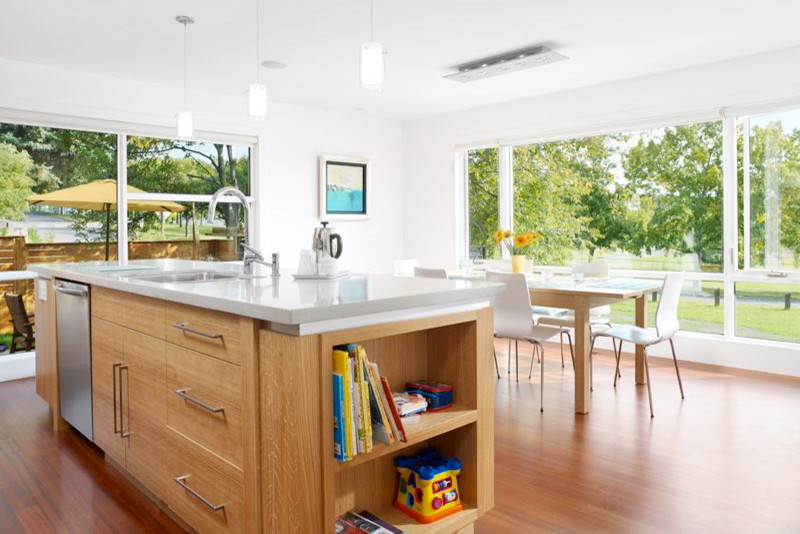Immagine di una cucina abitabile minimalista con ante lisce e ante in legno chiaro
