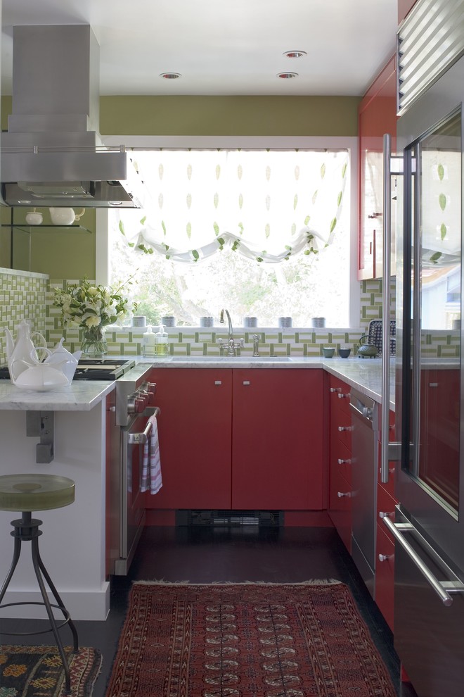 Stilmix Küche in U-Form mit flächenbündigen Schrankfronten, roten Schränken, Küchenrückwand in Grün und Küchengeräten aus Edelstahl in Denver