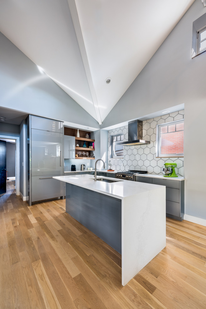 Immagine di una cucina moderna con parquet chiaro, pavimento beige, lavello sottopiano, ante lisce, ante blu, paraspruzzi bianco, paraspruzzi in gres porcellanato, elettrodomestici in acciaio inossidabile e top bianco