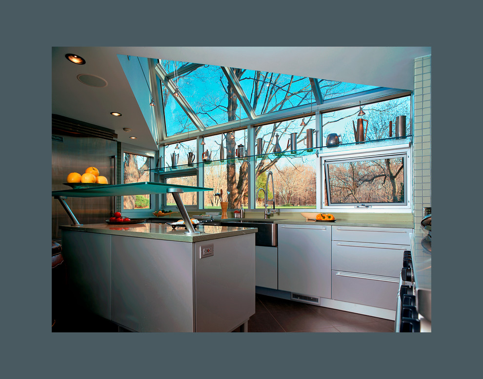 ニューヨークにある中くらいなコンテンポラリースタイルのおしゃれなキッチン (エプロンフロントシンク、フラットパネル扉のキャビネット、ステンレスキャビネット、シルバーの調理設備) の写真