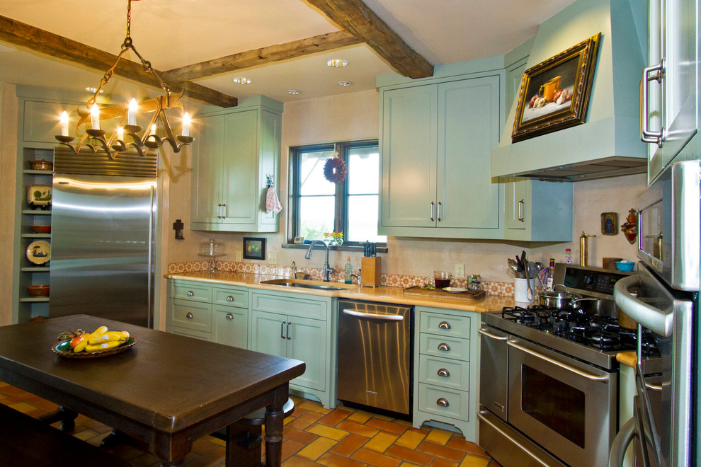 Immagine di una grande cucina stile americano con lavello sottopiano, ante in stile shaker, ante verdi, top in granito, paraspruzzi multicolore, elettrodomestici in acciaio inossidabile e pavimento in terracotta