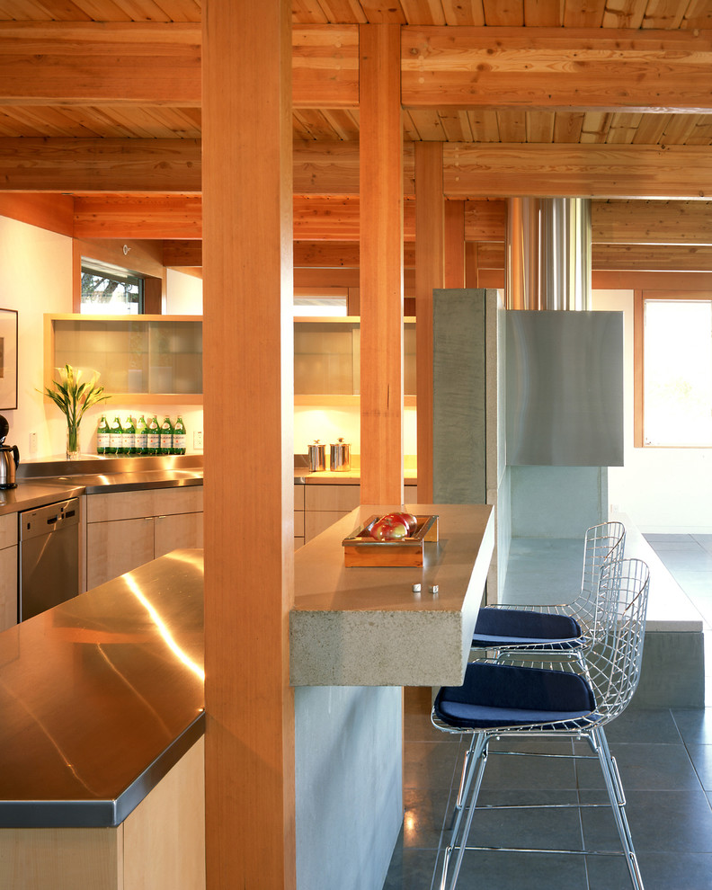 Inspiration för mellanstora moderna l-kök, med rostfria vitvaror, bänkskiva i rostfritt stål, luckor med glaspanel och en köksö