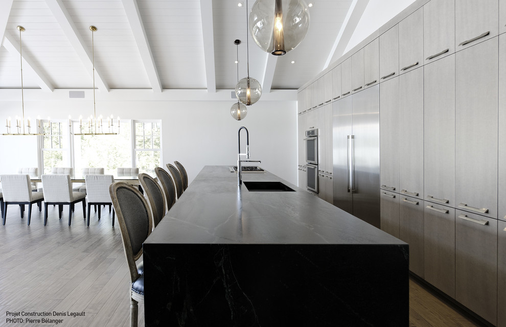Пример оригинального дизайна: огромная прямая кухня в стиле модернизм с обеденным столом, столешницей из талькохлорита и островом