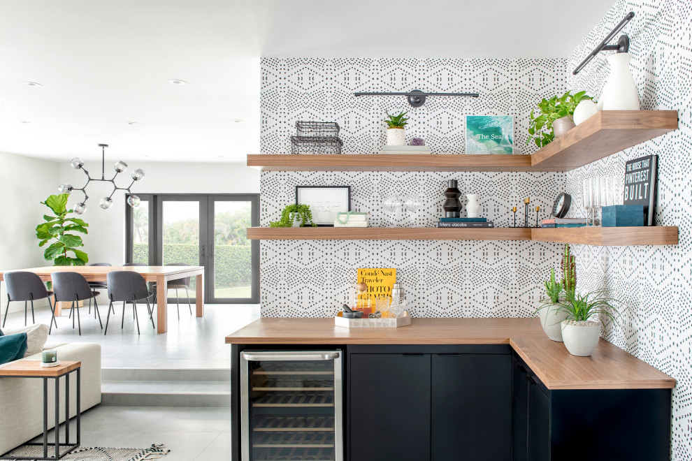 Foto di una cucina a L minimal di medie dimensioni con ante lisce, ante nere, top in legno, paraspruzzi multicolore, elettrodomestici in acciaio inossidabile e top marrone