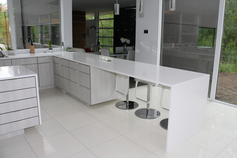 Exempel på ett stort modernt kök, med en undermonterad diskho, släta luckor, vita skåp, bänkskiva i kvarts, rostfria vitvaror, klinkergolv i keramik, en köksö, fönster som stänkskydd och vitt golv