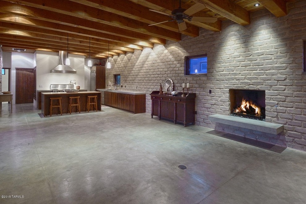 Immagine di una grande cucina contemporanea con lavello da incasso, ante lisce, ante in legno scuro, elettrodomestici in acciaio inossidabile e pavimento in cemento