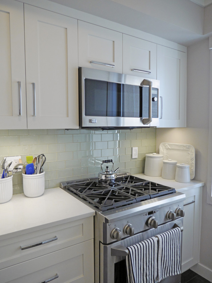 Example of a small trendy galley enclosed kitchen design in New York with an undermount sink, shaker cabinets, quartzite countertops, green backsplash, glass tile backsplash, stainless steel appliances and no island