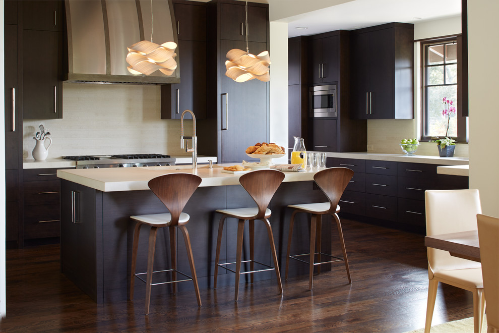 Mid-sized trendy l-shaped dark wood floor eat-in kitchen photo in San Francisco with flat-panel cabinets, dark wood cabinets, beige backsplash, an island, an undermount sink, quartz countertops, stone tile backsplash and stainless steel appliances
