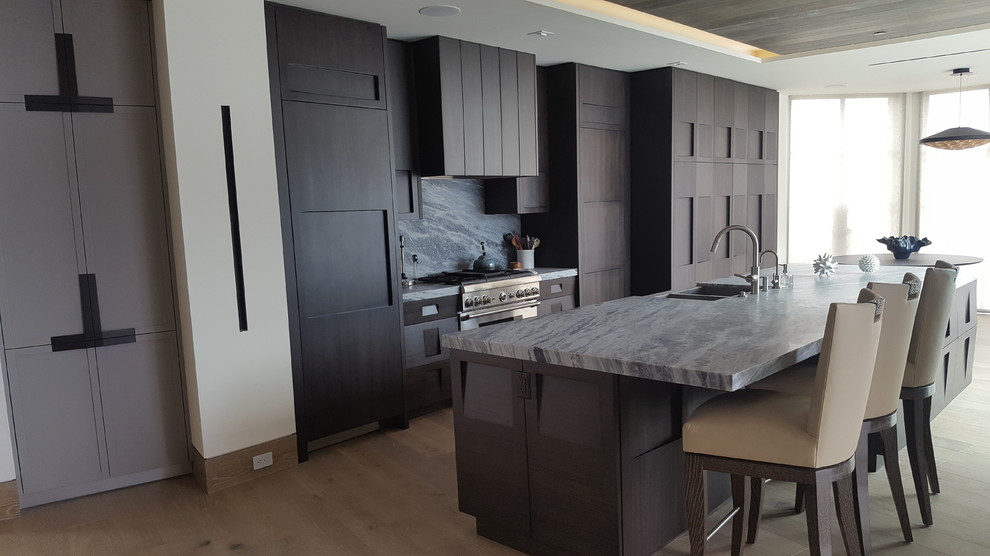 Photo of a large modern single-wall kitchen/diner in Orange County with recessed-panel cabinets, dark wood cabinets, marble worktops, grey splashback, marble splashback, stainless steel appliances, an island and grey worktops.