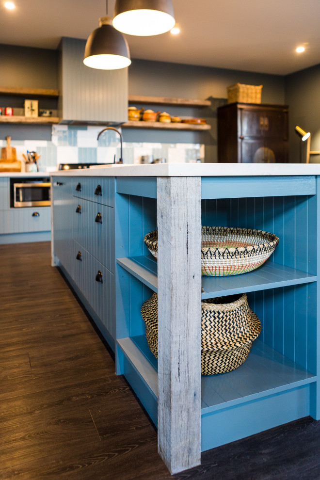 Foto di una cucina design con lavello da incasso, ante a persiana, ante blu, paraspruzzi blu, paraspruzzi con piastrelle in ceramica, elettrodomestici neri, parquet scuro, pavimento marrone e top bianco