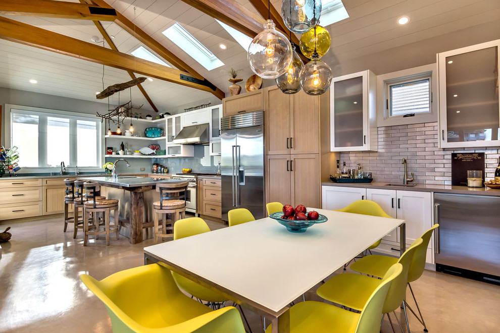 Example of a mid-sized trendy u-shaped concrete floor eat-in kitchen design in San Francisco with shaker cabinets, light wood cabinets, quartz countertops, gray backsplash, glass sheet backsplash, stainless steel appliances and an island