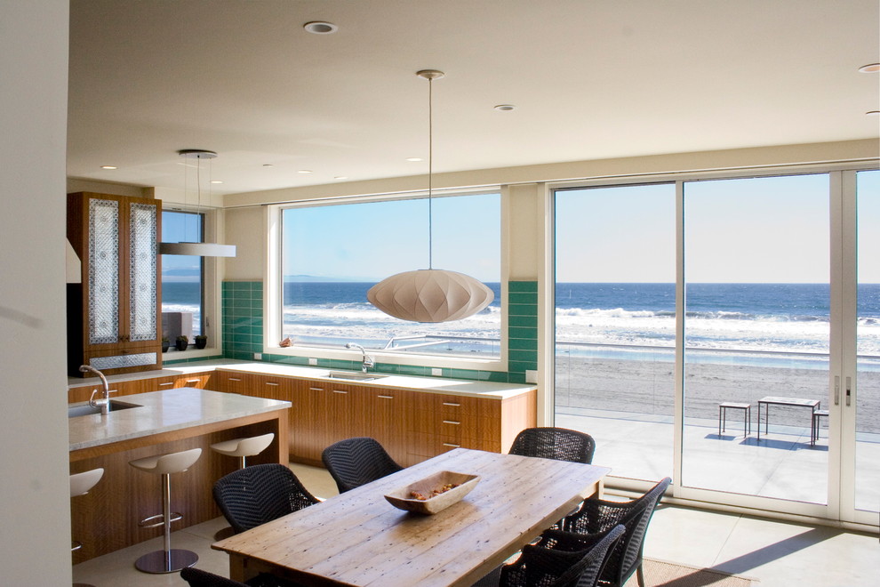 На фото: кухня в морском стиле с обеденным столом, плоскими фасадами и фасадами цвета дерева среднего тона
