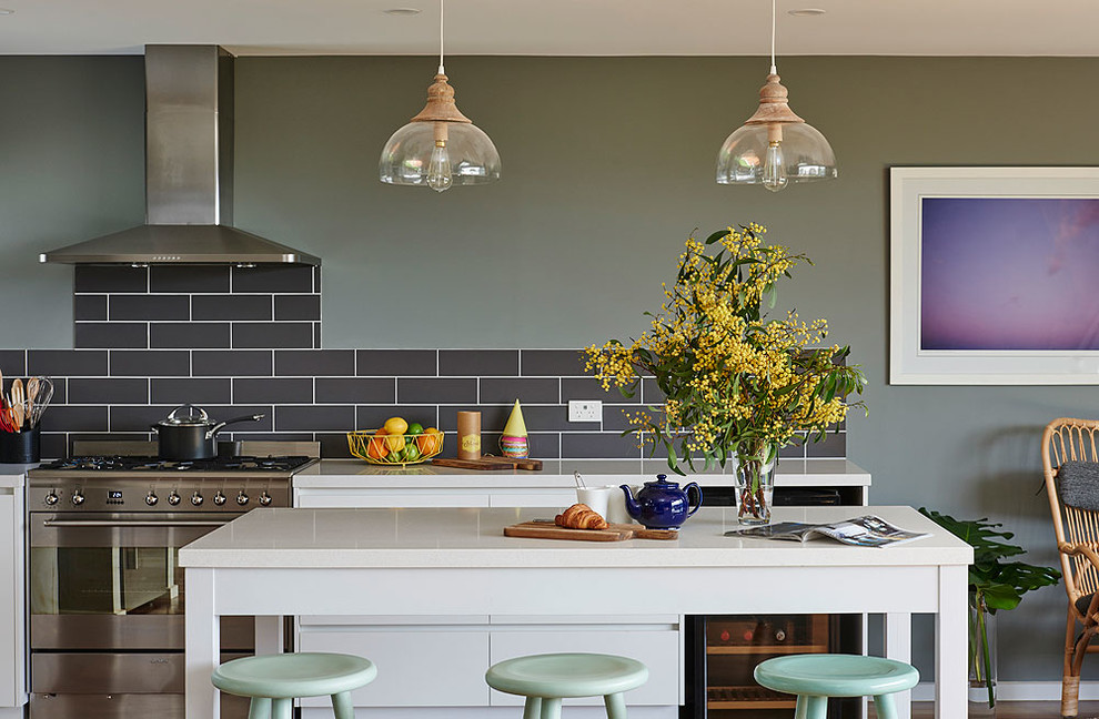 Example of a large transitional single-wall light wood floor eat-in kitchen design in Melbourne with a double-bowl sink, beaded inset cabinets, white cabinets, tile countertops, gray backsplash, ceramic backsplash, stainless steel appliances and an island