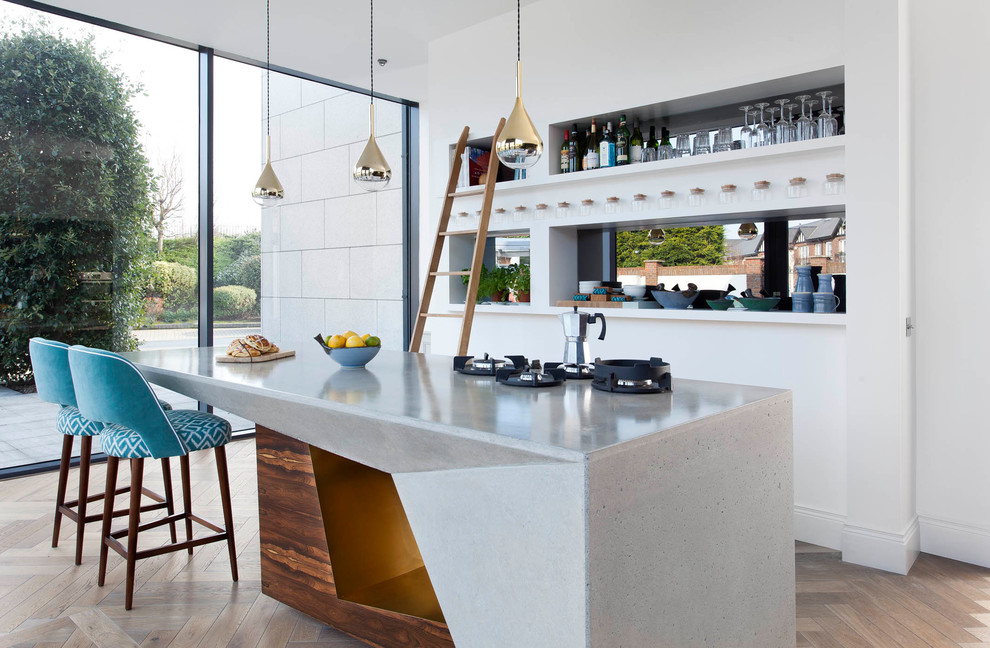 Immagine di una grande cucina design con top in cemento, pavimento in legno massello medio, pavimento beige e paraspruzzi a specchio