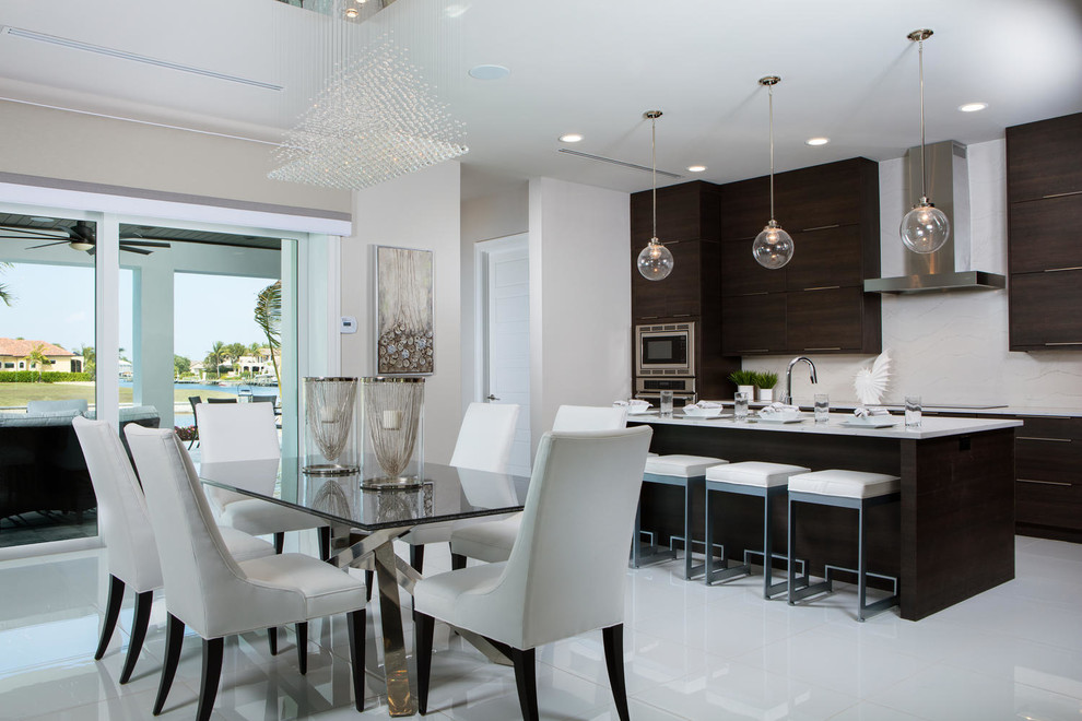Mid-sized trendy l-shaped porcelain tile and white floor open concept kitchen photo in Miami with flat-panel cabinets, quartz countertops, white backsplash, stainless steel appliances, an island and dark wood cabinets