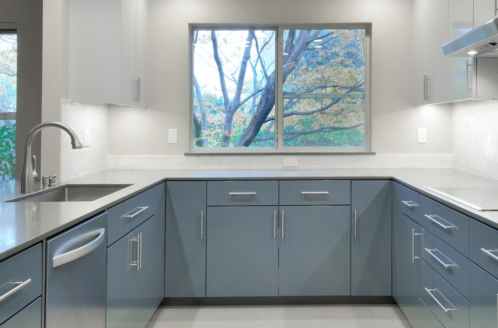 Mid-sized trendy u-shaped linoleum floor enclosed kitchen photo in Sacramento with an undermount sink, flat-panel cabinets, blue cabinets, solid surface countertops, gray backsplash, stone tile backsplash, stainless steel appliances and no island