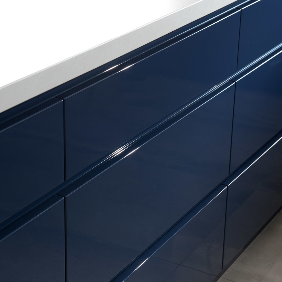 Exempel på ett mellanstort modernt kök, med en undermonterad diskho, släta luckor, blå skåp, bänkskiva i kvarts, vitt stänkskydd, stänkskydd i stenkakel, rostfria vitvaror, klinkergolv i porslin och en halv köksö