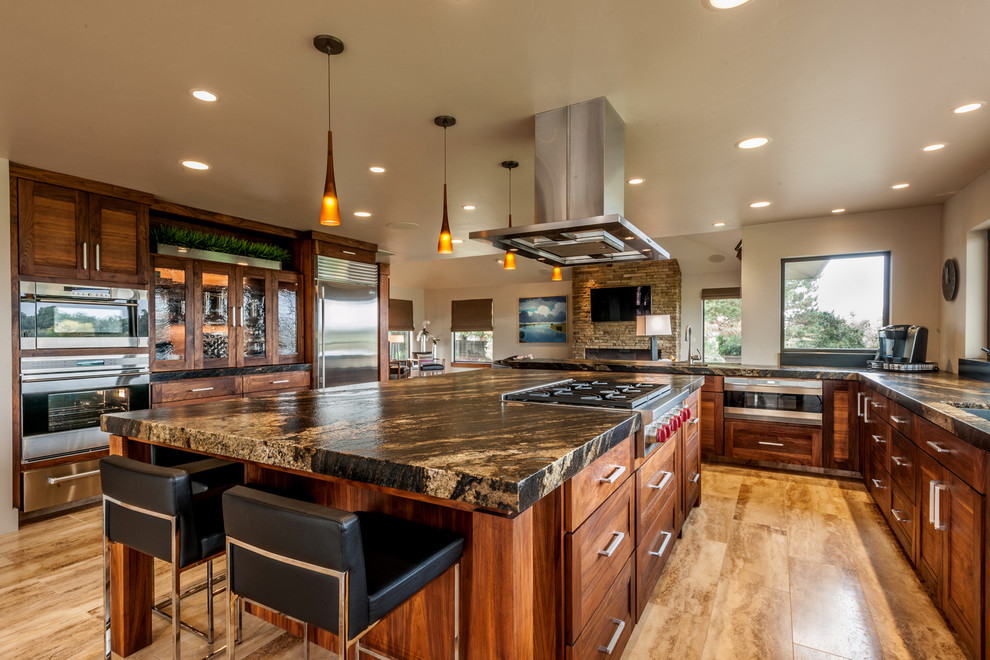 Contemporary kitchen in Sacramento with shaker cabinets, dark wood cabinets, granite worktops, stainless steel appliances and travertine flooring.
