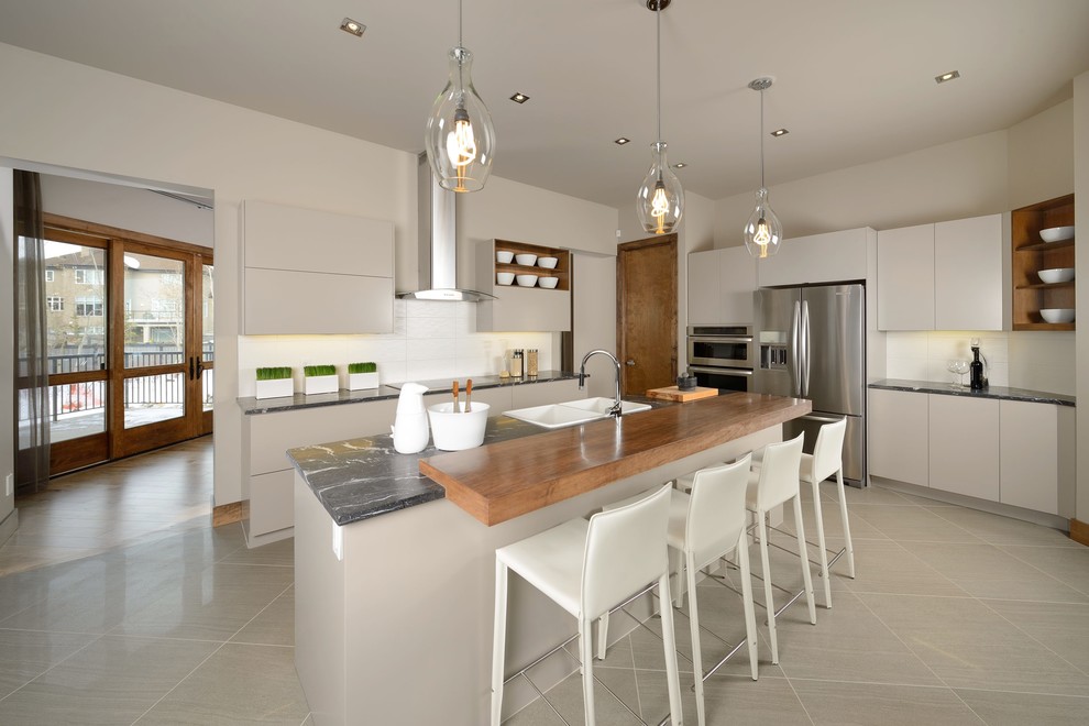 Idéer för ett modernt kök, med marmorbänkskiva, en nedsänkt diskho, luckor med upphöjd panel, beige skåp, vitt stänkskydd och rostfria vitvaror