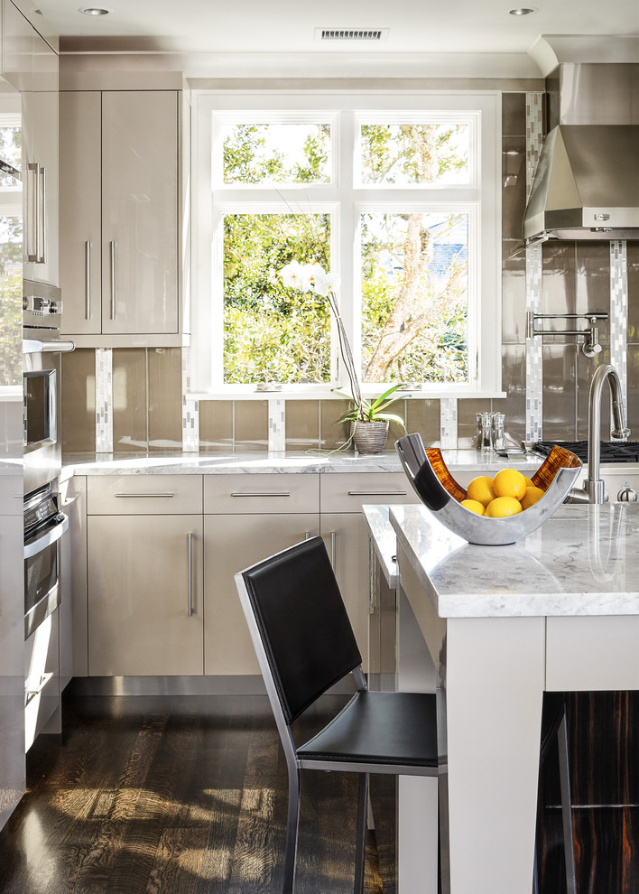 Large trendy u-shaped kitchen photo in Charleston with flat-panel cabinets, beige cabinets, granite countertops, brown backsplash, paneled appliances and two islands